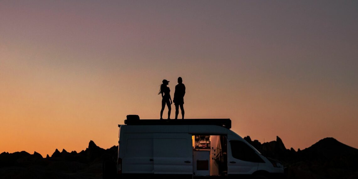 silhouette of couple on a van during sunset