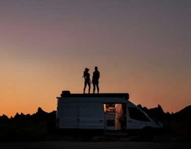 silhouette of couple on a van during sunset