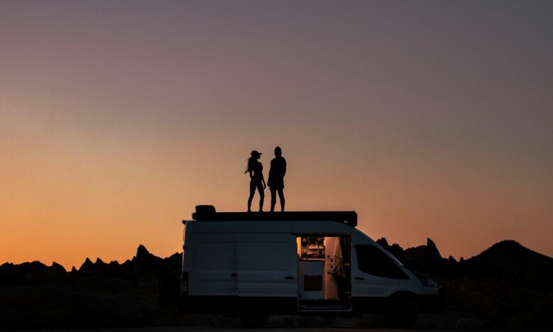 silhouette of couple on a van during sunset
