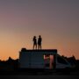 silhouette of couple on a van during sunset