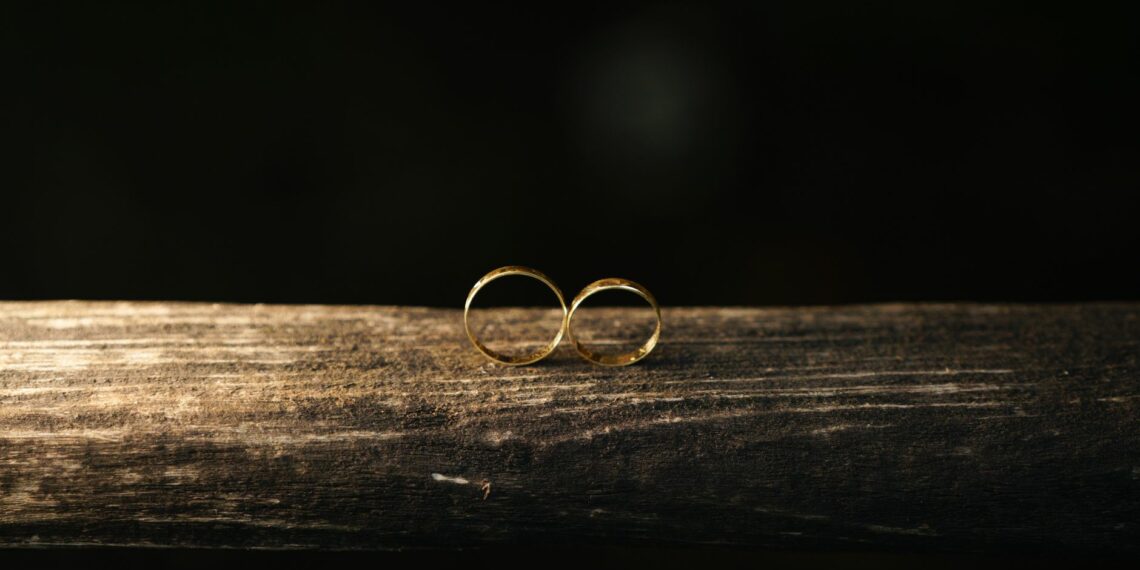 elegant gold wedding rings on rustic wood