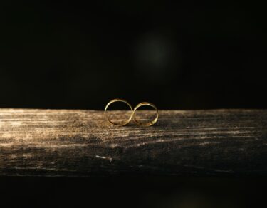 elegant gold wedding rings on rustic wood