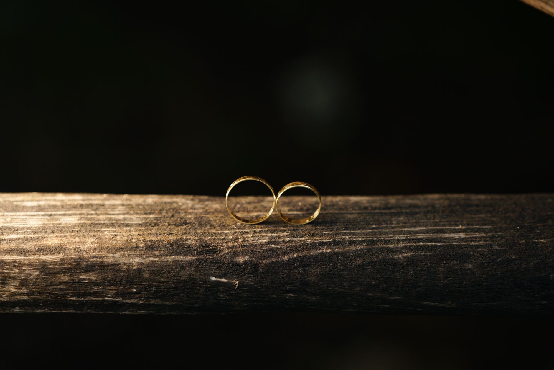 elegant gold wedding rings on rustic wood