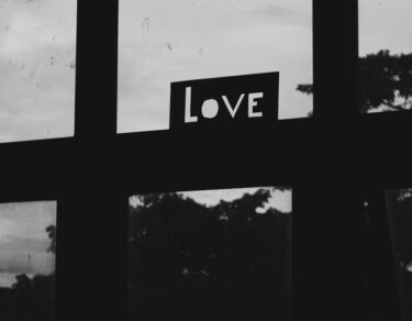 grayscale photo of a love sign on a window