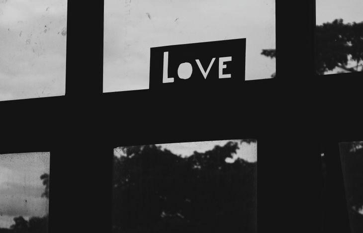 grayscale photo of a love sign on a window