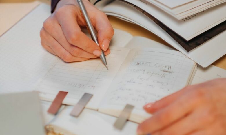 person writing on white paper